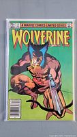 Front cover of Wolverine #4 comic book in a protective bag and board showing Wolverine holding a gun with a green background.