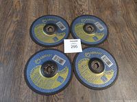 Top view of four new 7-inch cutoff discs labeled Abmasti Super arranged on a wooden surface showing front side.