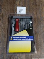 Photo of unopened Powerfist 8-piece chainsaw sharpening kit with wooden handle and various metal files in black carrying case with yellow and blue packaging label.