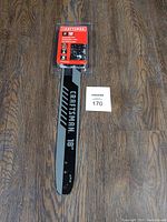 Full length photo of the Craftsman 18 inch chainsaw bar with the chain combo attached in packaging on wooden floor.