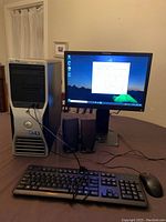 Front view of Dell Precision T5500 tower, Lenovo monitor, Dell keyboard, mouse and speakers arranged on table
