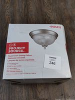 Box showing front of Project Source flushmount ceiling fixture with picture and brand and model information.