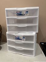 Two Sterilite plastic three-drawer storage units stacked, showing front and side profile with labels visible.
