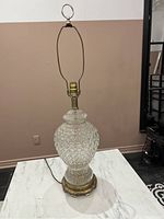 Full view of the vintage crystal lamp showing the diamond-cut glass body and brass base with attached lamp frame.