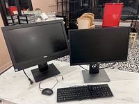 Overview of Dell desktop PC setup with two Dell monitors, keyboard, and mouse on a table.