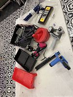 Photo showing assortment of painting tools including trays, sprayer, funnel, grip handle tool, and marker.