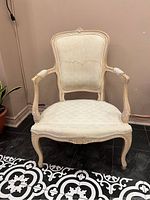 Front view of Queen Anne style armchair showing wood frame and upholstered seat and back with visible wear and staining