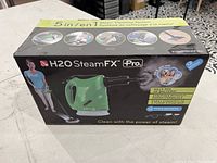 Box of H2O SteamFX Pro 5-in-1 steam cleaning system showing product image and features on packaging.