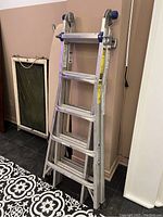 Ladder in folded A-frame configuration leaning against wall