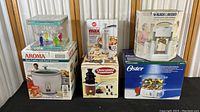Full view of all boxed kitchen items including rice cooker, food steamer, chocolate fountain, jar opener, and goblets