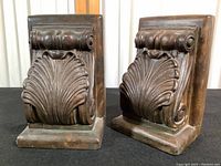 View of the pair of heavy plaster bookends showing front shell motif and scroll design