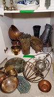 Shelved collection showing a variety of copper bowls, metal planters, wall pockets and pitchers