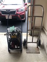 View of Sears Craftsman hand truck and metal cart holding a Dirt Devil vacuum cleaner in garage setting