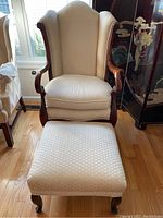 Front view of the wingback Queen Ann style chair and matching ottoman, showing overall design and condition.