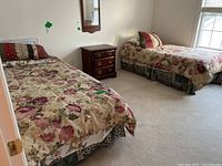 Overview of both twin bed setups with bedding, nightstand and wall mirror