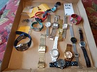 A top view of the 13 watches arranged inside a box, showing a mix of metal link, silicone, leather, and mesh bands.