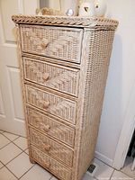 Front side view of the 6 drawer wicker lingerie chest showing woven drawer fronts and braided wicker top trim.