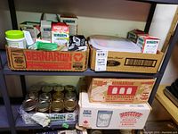 Shelves holding multiple boxes of Bernardin branded canning supplies including mason jars and lids.