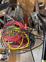 Photo showing multiple air hoses coiled and draped over the compressor unit, revealing the motor and parts of the frame.