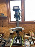 Front view of Craftex CT023 drill press mounted on workbench showing column, table, base, and feed lever.