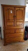 Frontal view of entire wardrobe showing two-door upper cabinet and four-drawer base