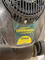 Close-up of Kohler XT 6.75 Series engine label on top of the green Yardworks lawnmower body.
