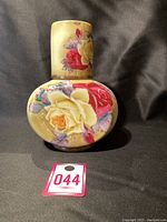 Front view of antique Nippon water carafe showing floral hand painted design with cream and red roses on cream background