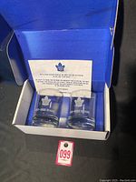 Two clear lowball Scotch glasses featuring Toronto Maple Leafs logo and season etched text, displayed in original blue box with membership team letter.