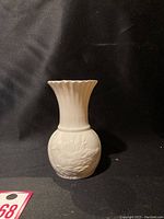 Front view of white porcelain bud vase with embossed Mallard duck design, showing the body shape and scalloped flared rim.