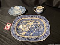 Photo showing the entire lot including serving platter, candy dish, and small pitcher with blue and white designs.