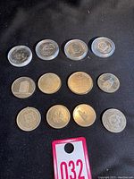 All 12 Canadian trade dollars and tokens arranged on black background. Various designs and metal finishes visible, many in individual protective capsules.