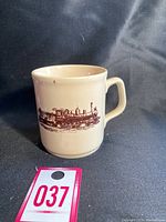 Front view of cream-colored ceramic mug with brown CN Rail steam locomotive graphic and handle visible, displayed against black background.