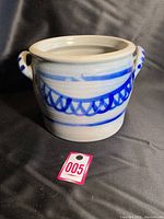 Front view of the vintage grey salt glazed stoneware crock with blue decorative painting and two side handles.