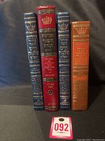 Four vintage religious hardcover leather Judaica books, shows spines with Hebrew text, embossed crowned emblems in gold.