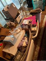 Photo of stacked cardboard boxes with visible household items including washcloths and a pink item on top.