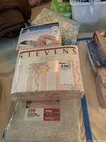 Photo includes Better Homes and Gardens King size mattress protector in beige sateen packaging along with other linens in clear packaging.