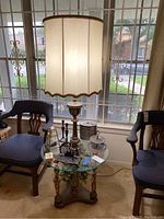 Full view of the lamp on the glass-top table with surrounding decor and chairs