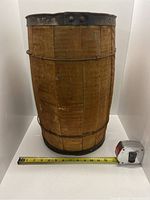 Front view of an oak nail keg with measuring tape showing approximately 12 inches diameter.