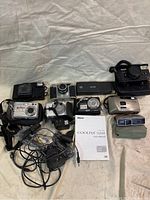 All cameras and accessories on a white cloth background