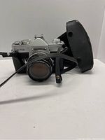Front view of Fujica ST701 camera with lens and leather case behind