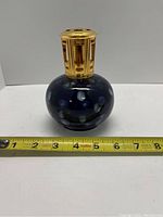 Full front view of the blue ceramic Lampe Berger diffuser lamp with gold-tone ventilated top and measuring tape at the base showing approximately 4.5 inches height.