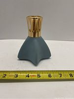 Front view of blue star-shaped diffuser lamp with gold metal top.