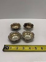 Four vintage Birks sterling silver nut dishes arranged with a measuring tape showing approximately 2.5 inch width.