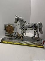 Full side view of the electric horse clock showing the horse figurine and clock face.