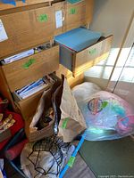 Open cabinet drawers with bags and boxes of craft supplies