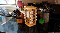 Image of JA Henckels knife block and wooden spice rack on kitchen countertop