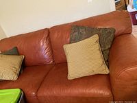 Front view of three-seat leather sofa with cushions