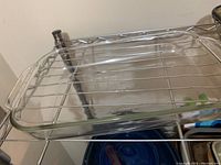 Clear glass Anchor Hocking roaster pan on metal shelf, showing overall shape and size.