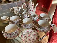 Overview of all porcelain pieces laid out on glass table.