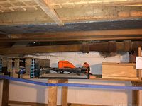 Photo showing long shelf with boxed 12" dovetail jig, orange tile cutter, and other tools.